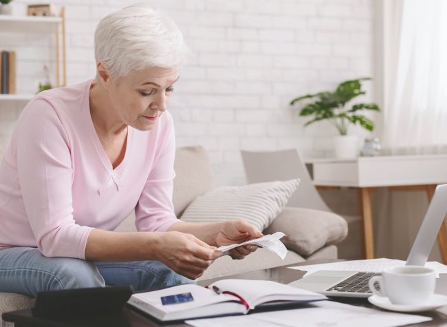 Senior lady counting finances and bills and home, empty space